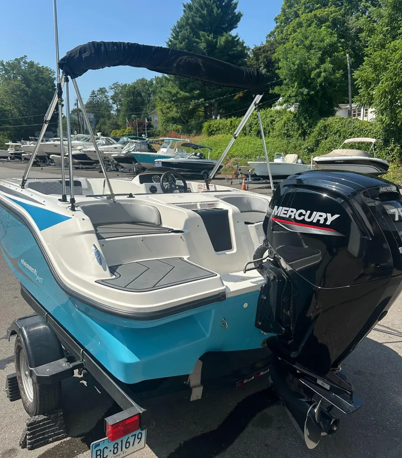 Slide: The Image of 2022 Bayliner Element M17 boat with Mercury engine on trailer, parked outdoors. - 5