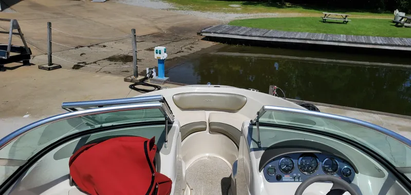 Slide: The Image of 2005 Sea Ray 200 Sport boat docked at a marina with a red cover. - 17