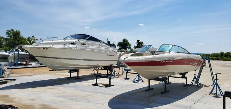 Slide: The Image of Two boats on stands, including a 2005 Sea Ray 200 Sport, under a clear blue sky. - 18