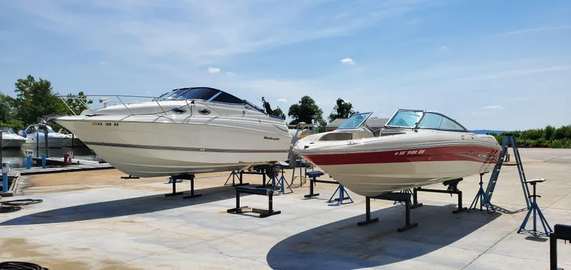 Slide: The Image of Two boats on stands, including a 2005 Sea Ray 200 Sport, under a clear blue sky. - 19