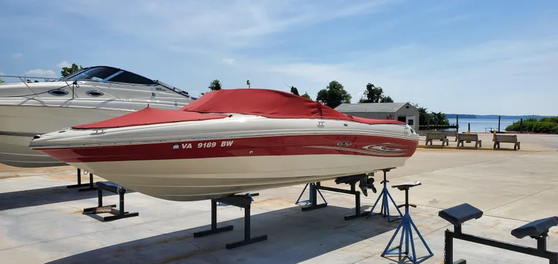 Slide: The Image of 2005 Sea Ray 200 Sport boat with red cover on stands, dockside view. - 4