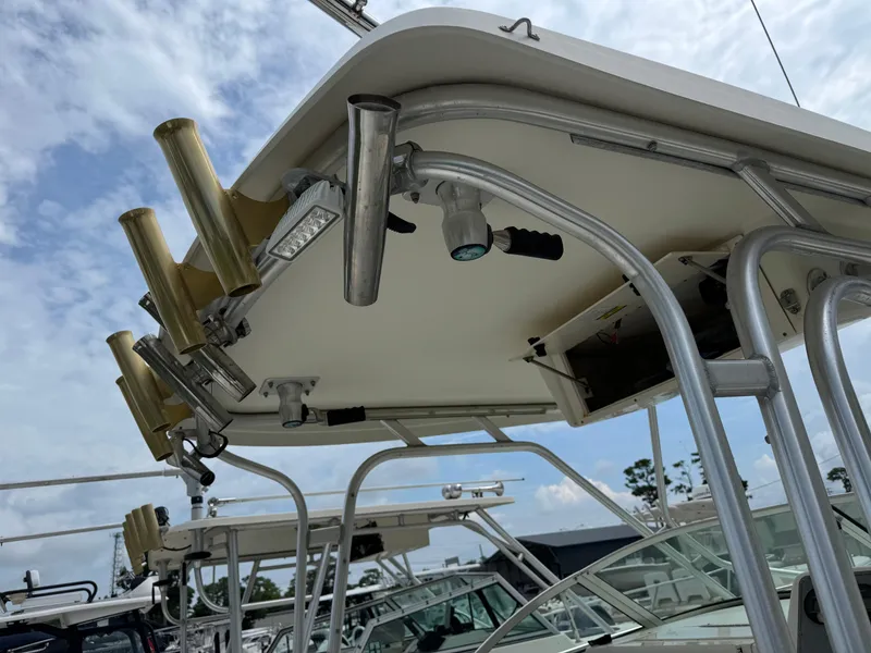 Slide: The Image of 2006 Hydrosport 23wa boat with rod holders and canopy, under a cloudy sky. - 5