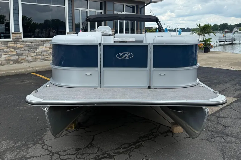 Slide: The Image of 2022 Bentley Pontoons 220CR boat docked near a waterfront building. - 4