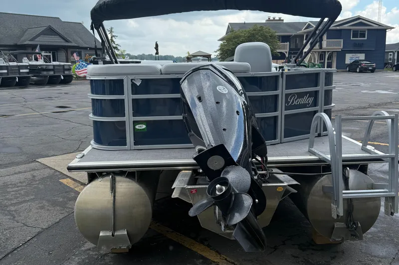 Slide: The Image of 2022 Bentley Pontoons 220CR with outboard motor, parked in a marina lot. - 5