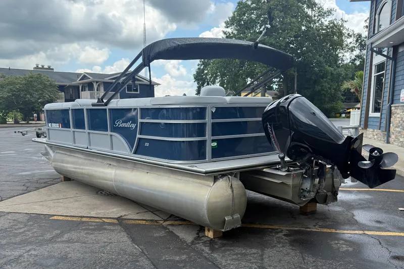 Slide: The Image of 2022 Bentley Pontoons 220CR boat with outboard motor, parked outdoors on a cloudy day. - 8