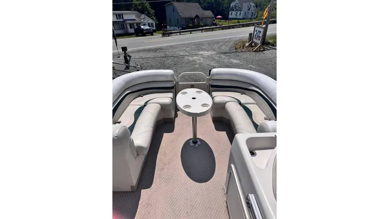 Slide: The Image of 2007 Starcraft Elite 206 RE boat interior with seating and table, parked near a road. - 3