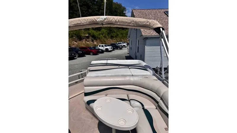 Slide: The Image of 2007 Starcraft Elite 206 RE pontoon boat with seating and table, parked near a building. - 4