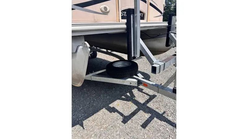 Slide: The Image of 2007 Starcraft Elite 206 RE boat trailer with spare tire on gravel surface. - 5