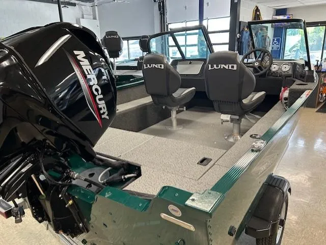 Slide: The Image of 2026 Lund 1650 Angler Sport boat interior with Mercury engine, featuring seating and dashboard. - 5