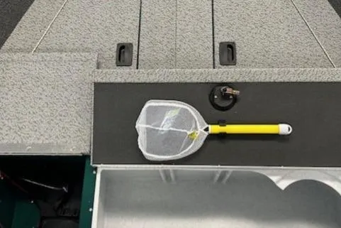 Slide: The Image of 2026 Lund 1650 Angler Sport boat deck with fishing net and accessories. - 8