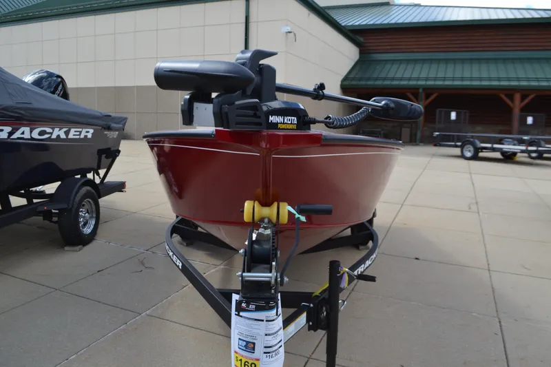 Slide: The Image of 2025 Tracker Super Guide V-16 T boat with Minn Kota motor displayed outdoors. - 2