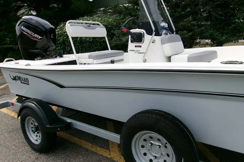 Slide: The Image of 2025 Mako Pro Skiff 17 CC boat on trailer with Mercury outboard motor. - 1