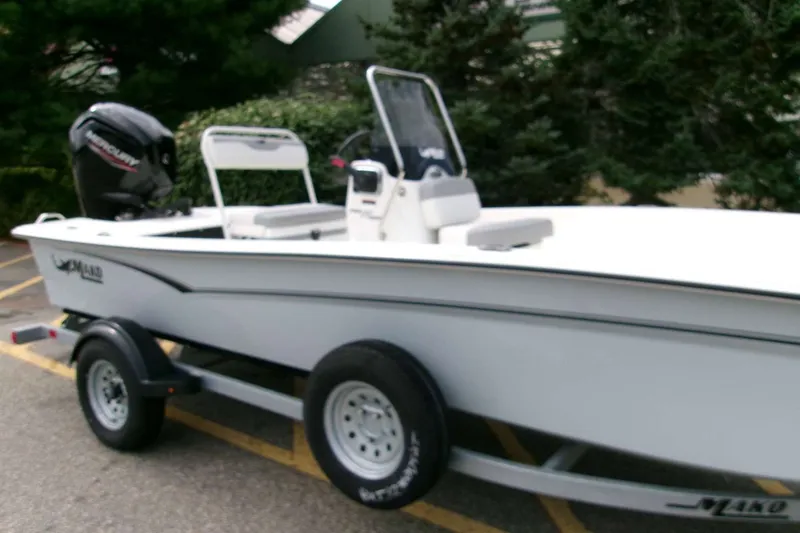 Slide: The Image of 2025 Mako Pro Skiff 17 CC boat on trailer, parked outdoors. - 2