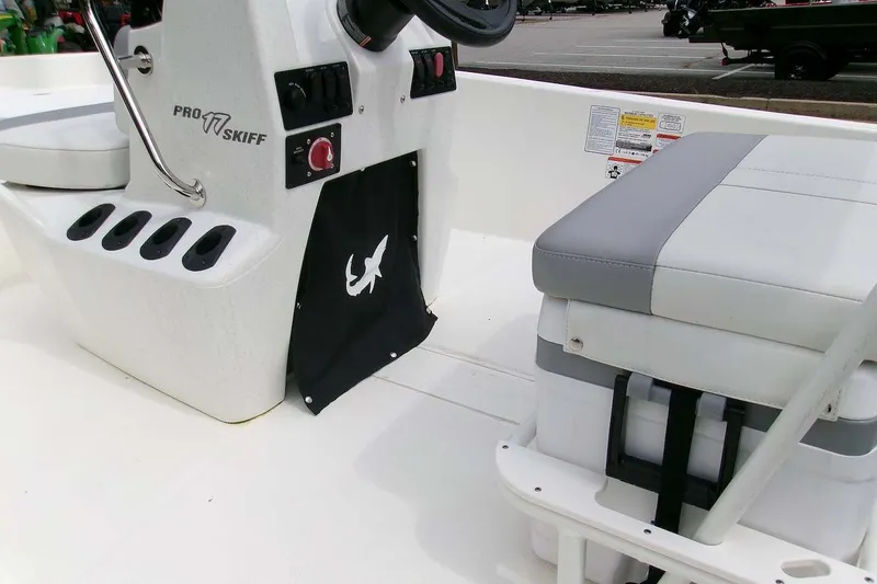 Slide: The Image of 2025 Mako Pro Skiff 17 CC boat interior with console and cushioned seat. - 5