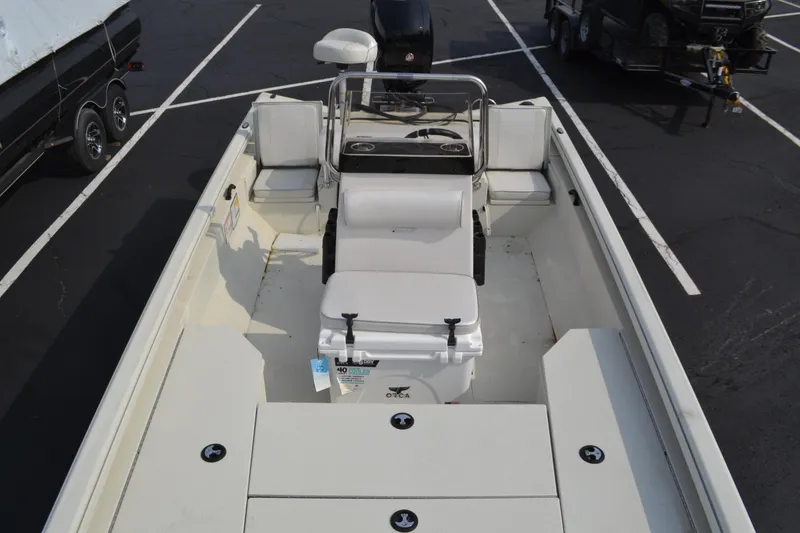 Slide: The Image of 2024 Ranger RB200 boat interior with seating and console, parked in a lot. - 4