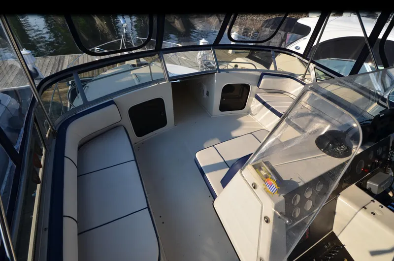 Slide: The Image of 1989 Carver SANTEGO boat interior with seating and control panel, docked at marina. - 14