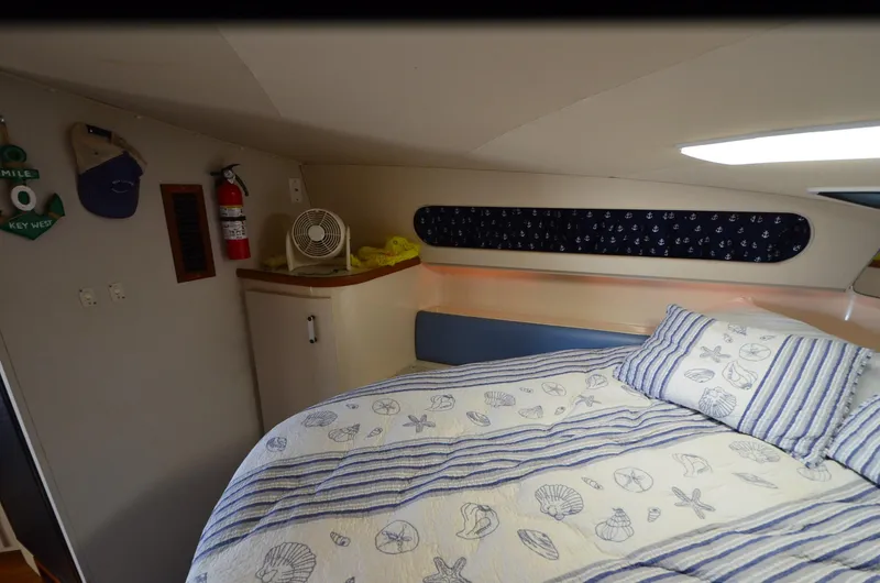 Slide: The Image of Cozy 1989 Carver SANTEGO cabin with nautical-themed bedding and decor. - 29