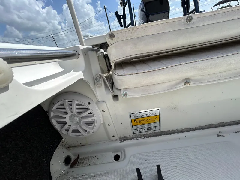 Slide: The Image of 1998 Action Craft 1820 Special Edition boat interior with speaker and seating, under a cloudy sky. - 12