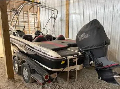 Slide: The Image of 2009 Ranger 211 Reata boat with covered motor, parked in a storage facility. - 2
