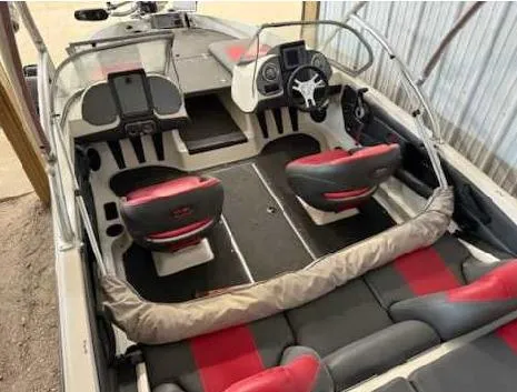 Slide: The Image of 2009 Ranger 211 Reata boat interior with red and gray seating, steering console, and storage compartments. - 3
