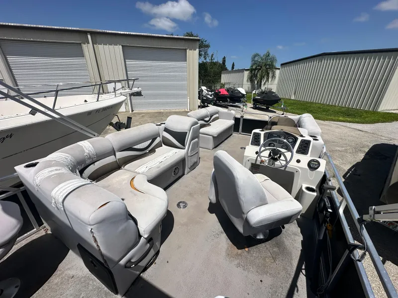 Slide: The Image of 2016 Qwest LS 820 Cruise pontoon boat with spacious seating, parked outdoors. - 13