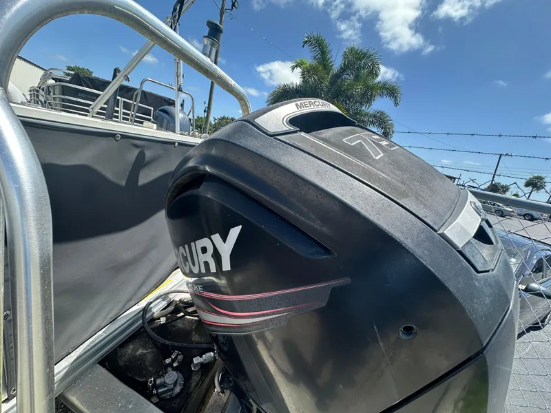 Slide: The Image of 2016 Qwest LS 820 Cruise with Mercury outboard motor, sunny day, palm trees in background. - 9