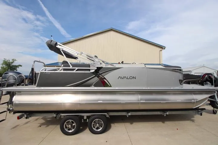 The Image of 2025 Avalon LSZ Quad Lounger Shift pontoon boat on trailer, parked outdoors. - 0