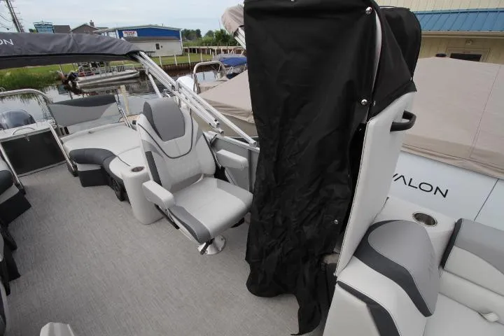 Slide: The Image of 2025 Avalon LSZ Quad Lounger Shift boat interior with gray seating and black cover. - 10