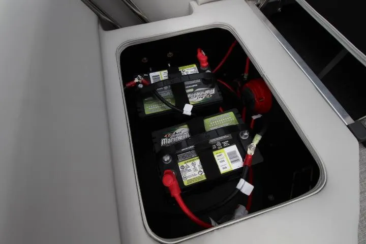 Slide: The Image of Battery compartment of 2025 Avalon LSZ Quad Lounger Shift boat, featuring dual marine batteries. - 7
