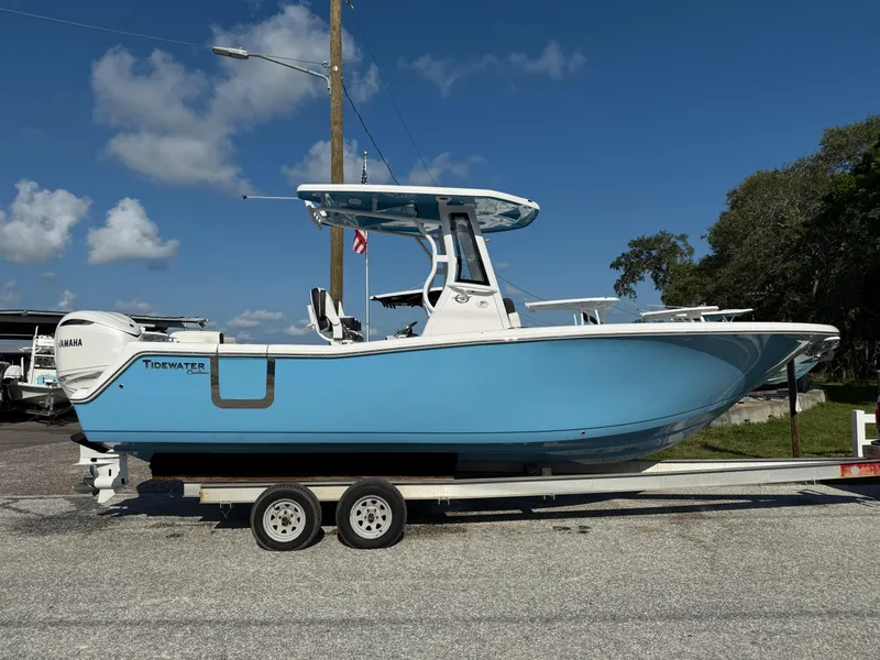 Slide: The Image of 2026 Tidewater 256 LXF boat on trailer, blue hull, clear sky background. - 1