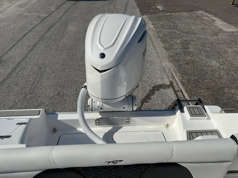 Slide: The Image of 2026 Tidewater 256 LXF boat with a sleek outboard motor, viewed from the rear. - 10