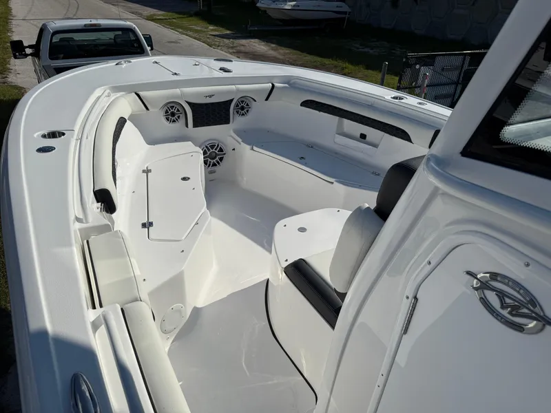 Slide: The Image of 2026 Tidewater 256 LXF boat interior with seating and speakers, parked on a trailer. - 11