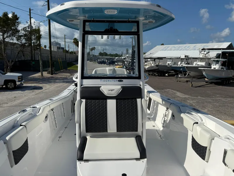 Slide: The Image of 2026 Tidewater 256 LXF boat interior with seating, docked under clear skies. - 12