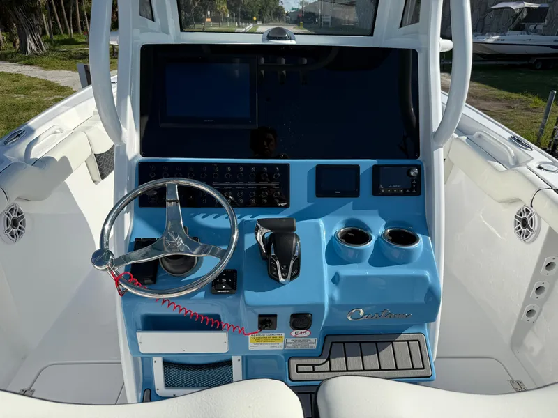 Slide: The Image of 2026 Tidewater 256 LXF boat dashboard with steering wheel, controls, and cup holders. - 4