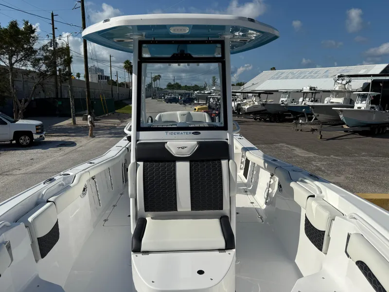 Slide: The Image of 2026 Tidewater 256 LXF boat interior with seating, docked under clear skies. - 6