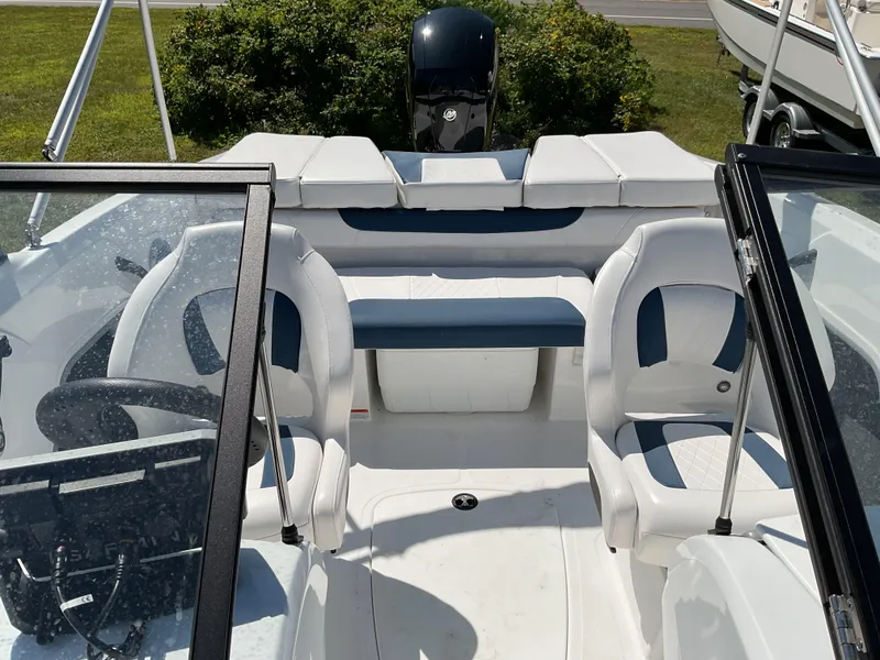 Slide: The Image of 2023 Tahoe 185 S boat interior with white and blue seating, steering wheel, and windshield. - 10