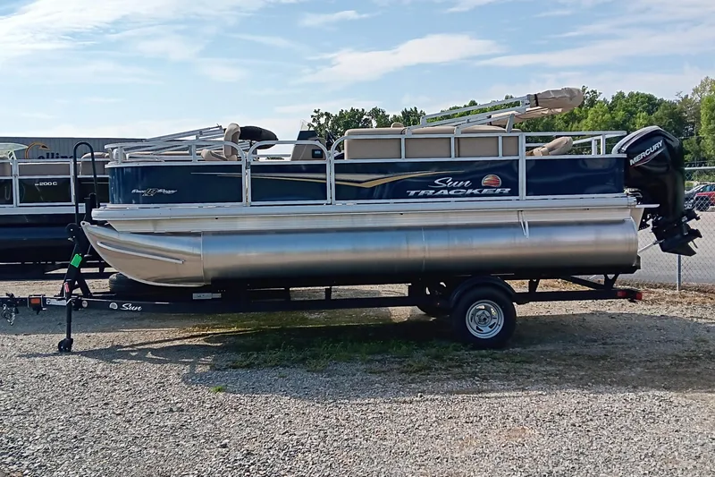 The Image of 2025 Sun Tracker Bass Buggy 18 DLX pontoon boat on trailer, outdoor setting. - 0