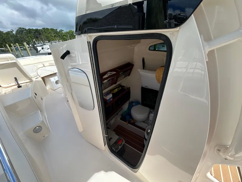 Slide: The Image of 2023 Grady-White 281 Coastal Explorer boat interior with open cabin door, showing storage and amenities. - 16