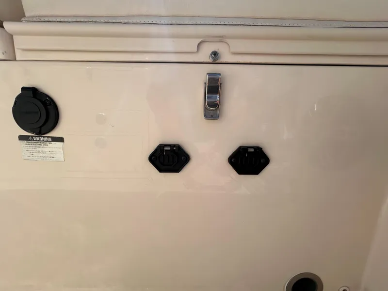 Slide: The Image of 2023 Grady-White 281 Coastal Explorer boat panel with warning label and connectors. - 4