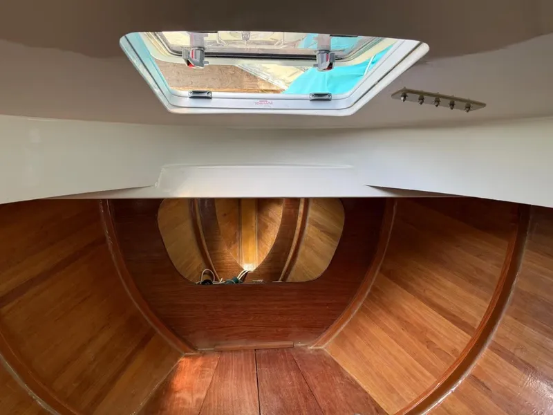 Slide: The Image of Interior view of 2022 AREY's XFC-22 boat, featuring wooden finish and overhead hatch. - 21