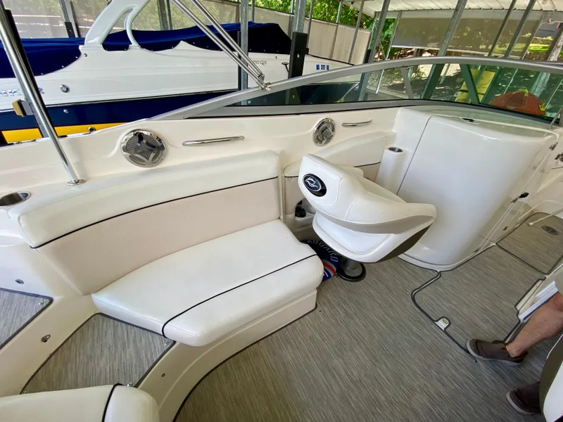 Slide: The Image of 2008 Rinker 246 Captiva Bowrider interior with white seating and steering area. - 18