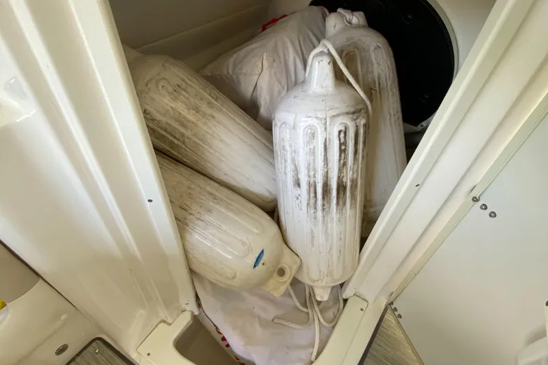 Slide: The Image of Storage compartment with boat fenders on a 2008 Rinker 246 Captiva Bowrider. - 19
