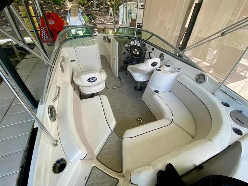 Slide: The Image of 2008 Rinker 246 Captiva Bowrider interior with white seating and steering console. - 26