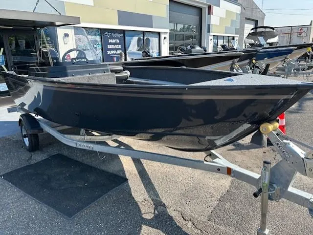 Slide: The Image of 2026 Lund 1650 Angler SS boat on trailer, parked outside dealership. - 2