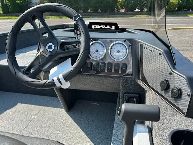 Slide: The Image of 2026 Lund 1650 Angler SS boat dashboard with steering wheel and gauges. - 5