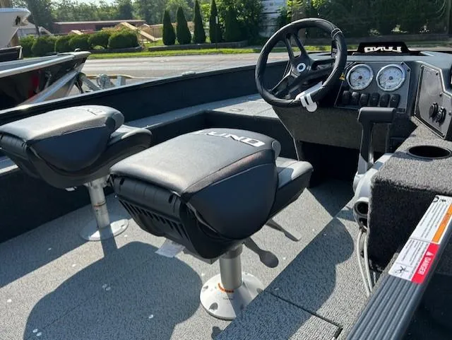 Slide: The Image of 2026 Lund 1650 Angler SS boat interior with steering wheel and seating. - 6