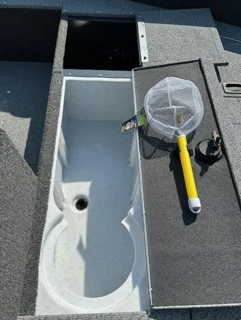 Slide: The Image of 2026 Lund 1650 Angler SS boat interior with storage compartment and fishing net. - 9