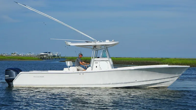 Slide: The Image of 2006 Regulator 32 FS boat on calm water with a person at the helm. - 10