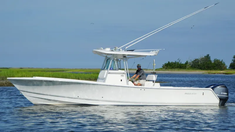 Slide: The Image of 2006 Regulator 32 FS boat cruising on calm water with scenic background. - 11