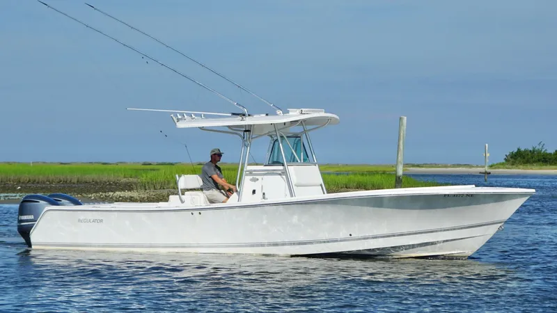 Slide: The Image of 2006 Regulator 32 FS boat on calm water, with a person at the helm. - 13